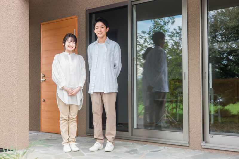 マイホーム前で笑顔の夫婦