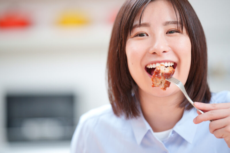 ハンバーグを美味しそうに食べる女性